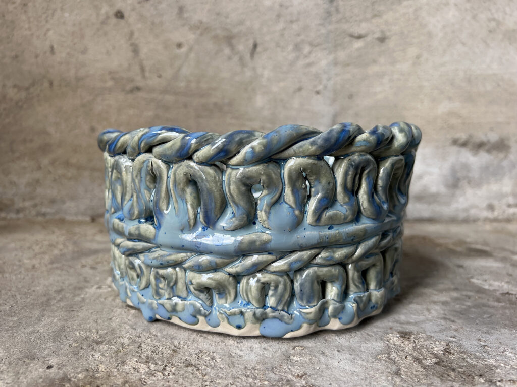 teal pot from the side with braided look.