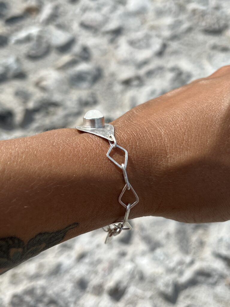 silver chain bracelet with white dragon codes holding a cabochon cut moonstone